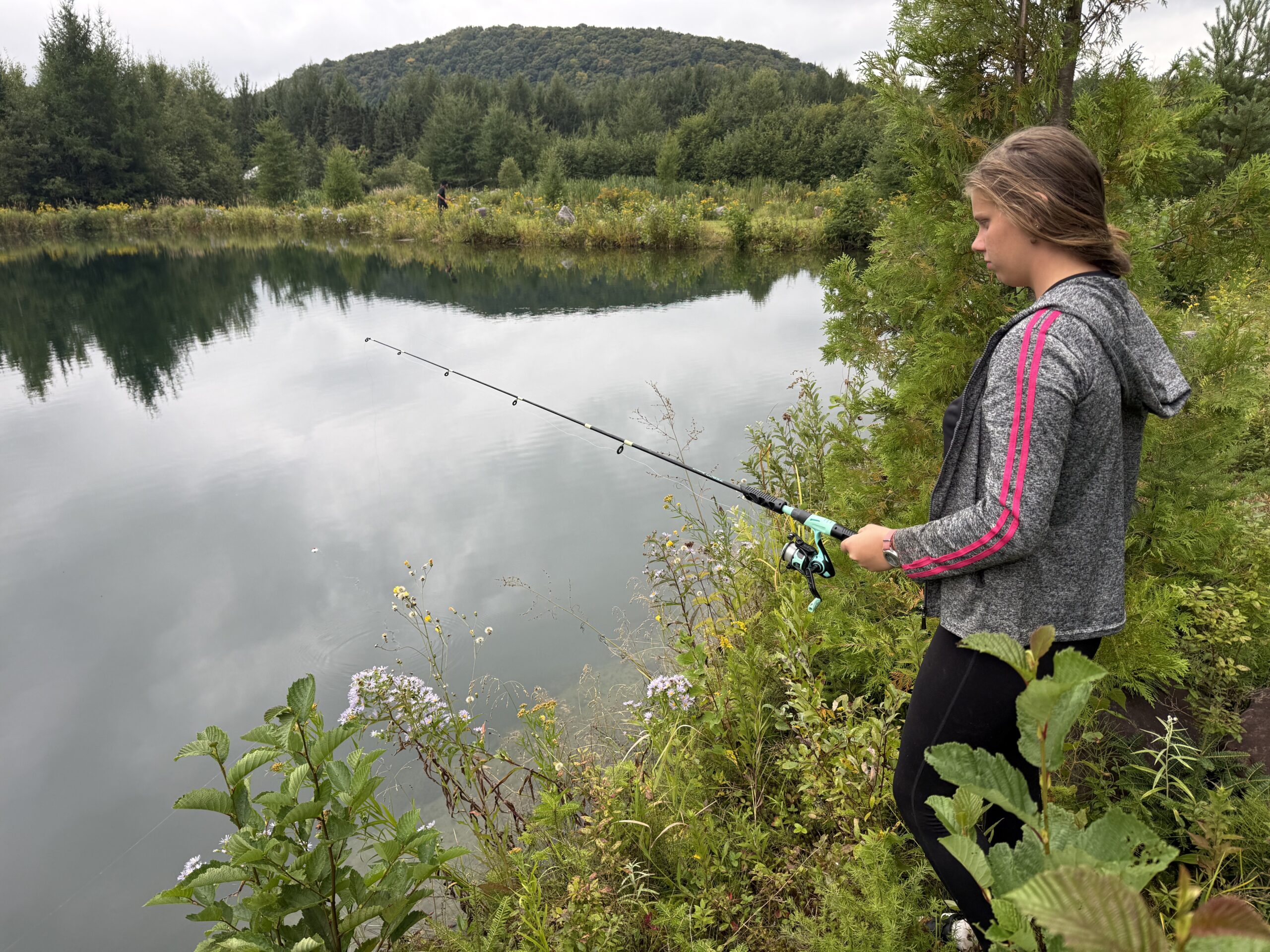a woman fishing on a lake with a rod, Val-des-Lacs, Québec, Canada