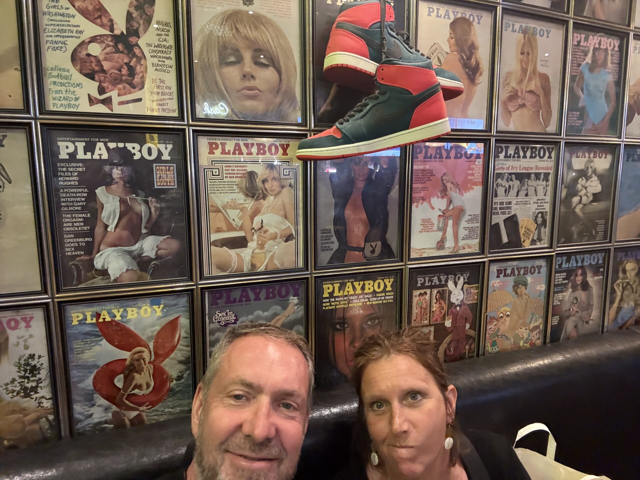 a man and woman sitting on a couch in front of a wall of magazines, Montréal, Québec, Canada
